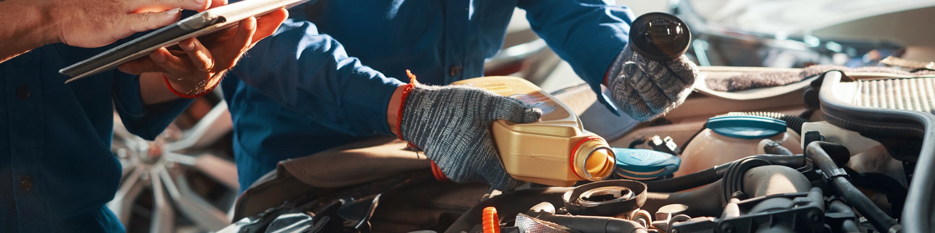 Mechanic Filling Car With Oil 